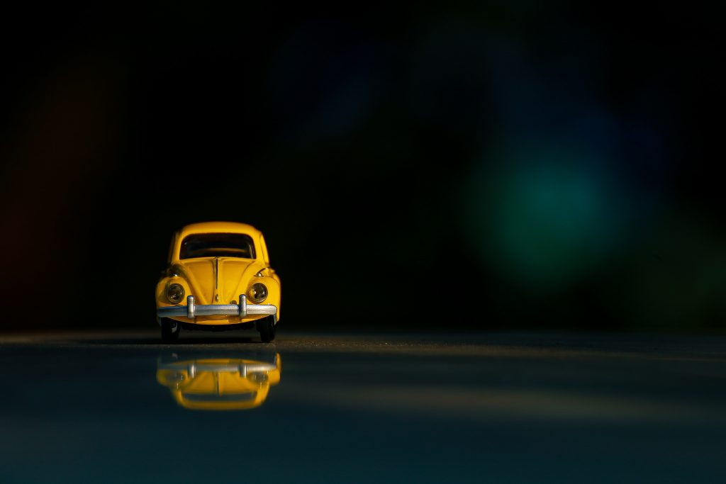 a small, yellow, toy car sits alone.