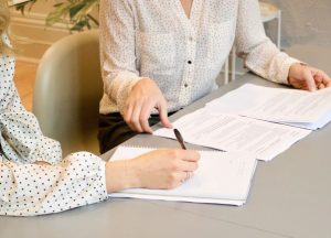 employee taking notes as employer outlines terms of new contract