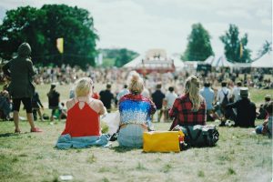 disappointed fans sit on the ground of a music festival.