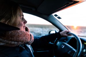 Woman, wearing a puffer jacket and a scary, drives her cold volvo.