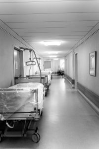 hospital beds lay along the wall of a hallway