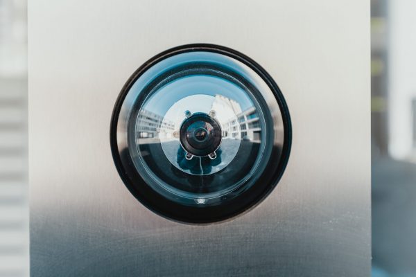 zoom into a doorbell camera, whose eye is looking right at the viewer.