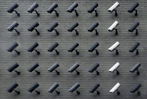 columns and rows of surveillance cameras all staring at a single location.