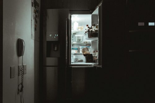 an open refrigerator in a dark room.