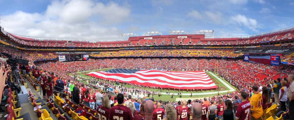 The American Football stadium for Washington. People stand for the national anthem.
