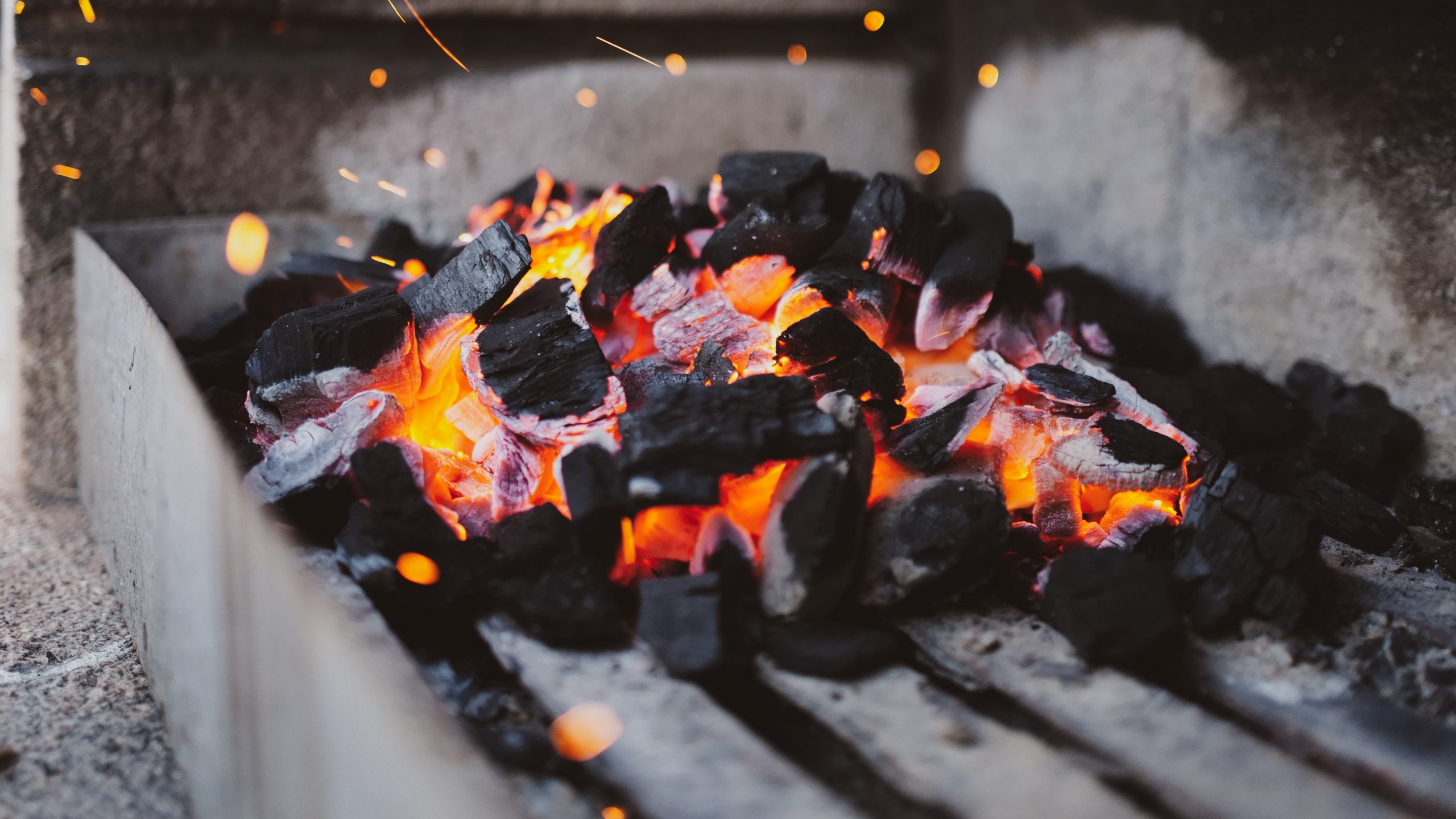 Coals burning on a barbecue pit.