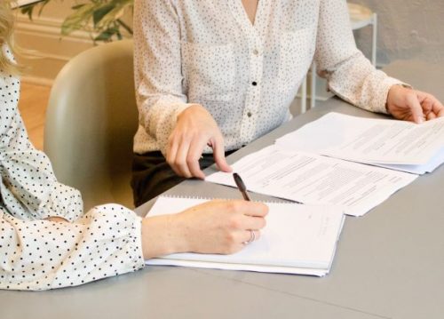 employee taking notes as employer outlines terms of new contract