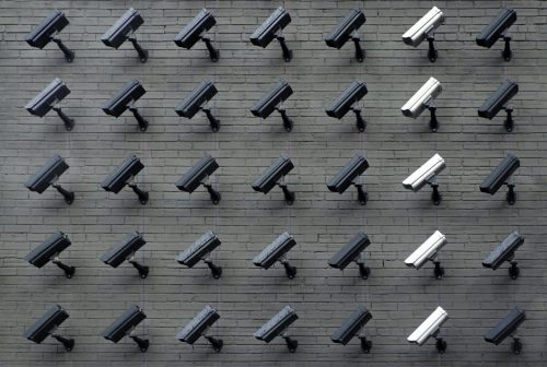 columns and rows of surveillance cameras all staring at a single location.